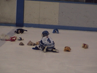 A Novice Waxer kneels down to gather up the stuffed animals after the Teddy Bear Toss.