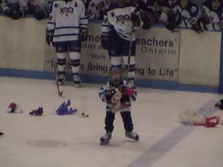 Using both hands, this Novice Waxer loads up on stuffed animals thrown  during the Teddy Bear Toss.